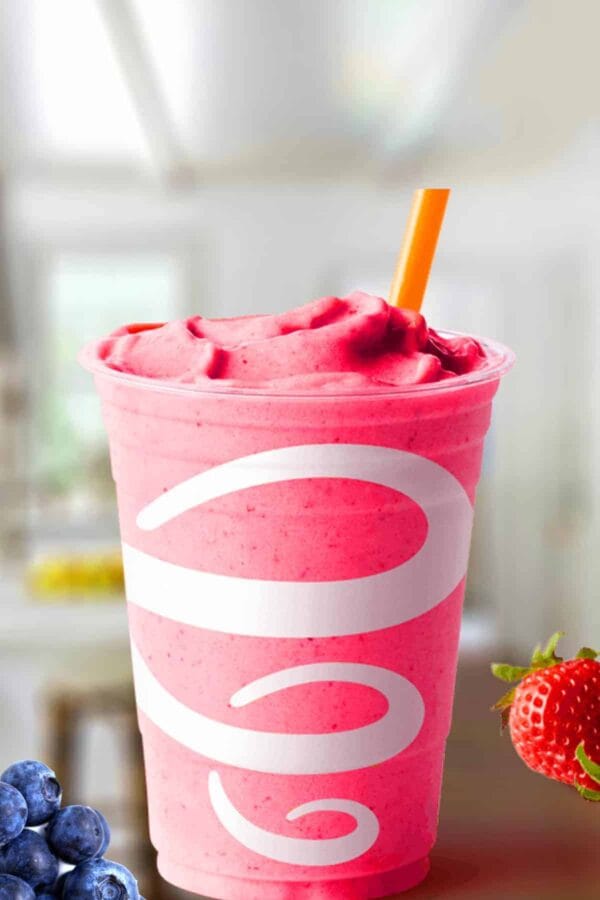 Jamba Juice Berry Blend smoothie in a glass, on my kitchen counter, surrounded by fresh berries.