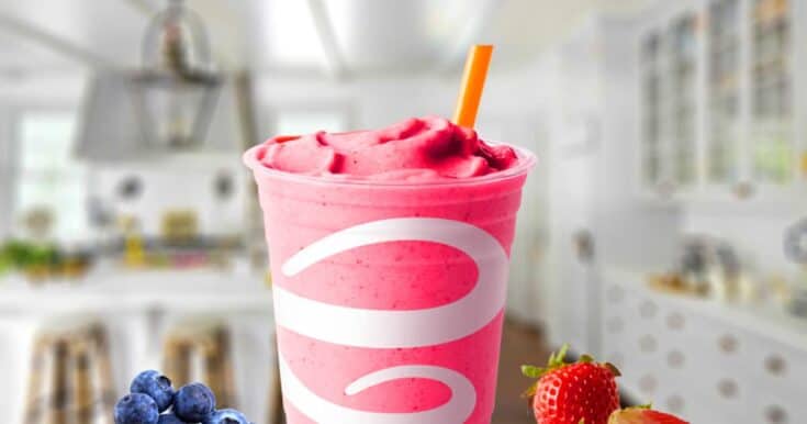 Jamba Juice Berry Blend smoothie in a glass, on my kitchen counter, surrounded by fresh berries.