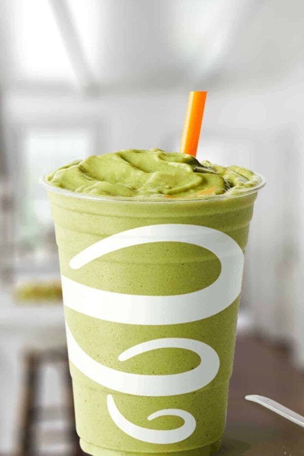 Jamba Juice Matcha Green Tea Blast smoothie in a glass, on my kitchen counter, surrounded by matcha green tea powder.