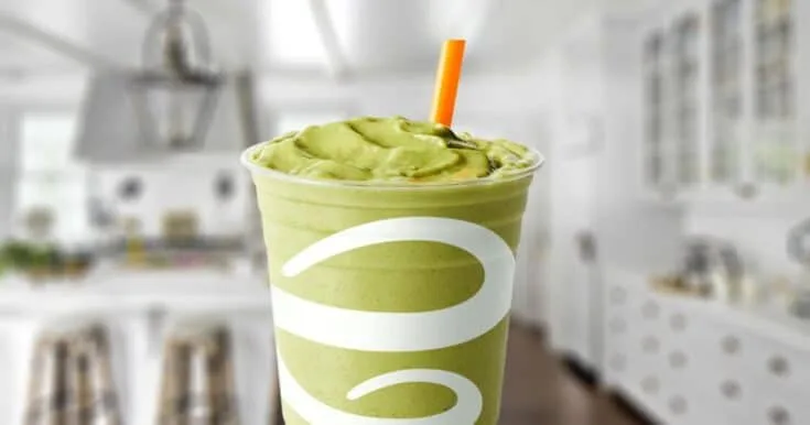Jamba Juice Matcha Green Tea Blast smoothie in a glass, on my kitchen counter, surrounded by matcha green tea powder.