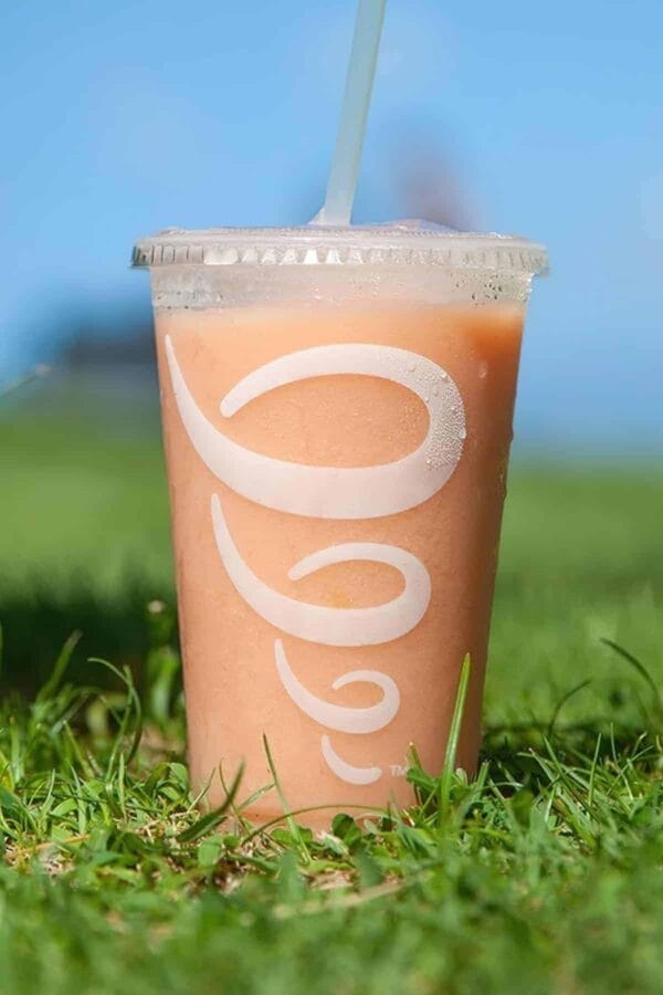 Jamba Juice Secret Menu Green Gummy Bear smoothie in a glass, outdoors.