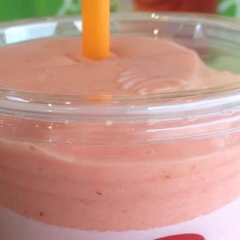 Jamba Juice Secret Menu Pink Starburst smoothie in a glass, on the counter in the store.