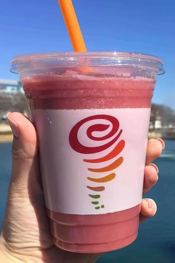 Jamba Juice Secret Menu Raspberry Dreamin' smoothie in a glass, outdoors.