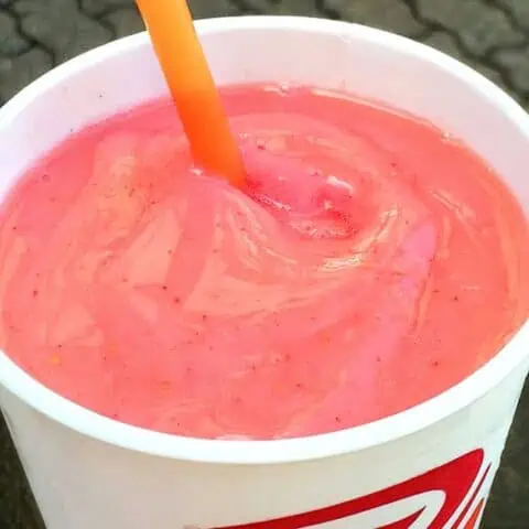 Jamba Juice Secret Menu Sour Patch Kids smoothie in a glass, outdoors.