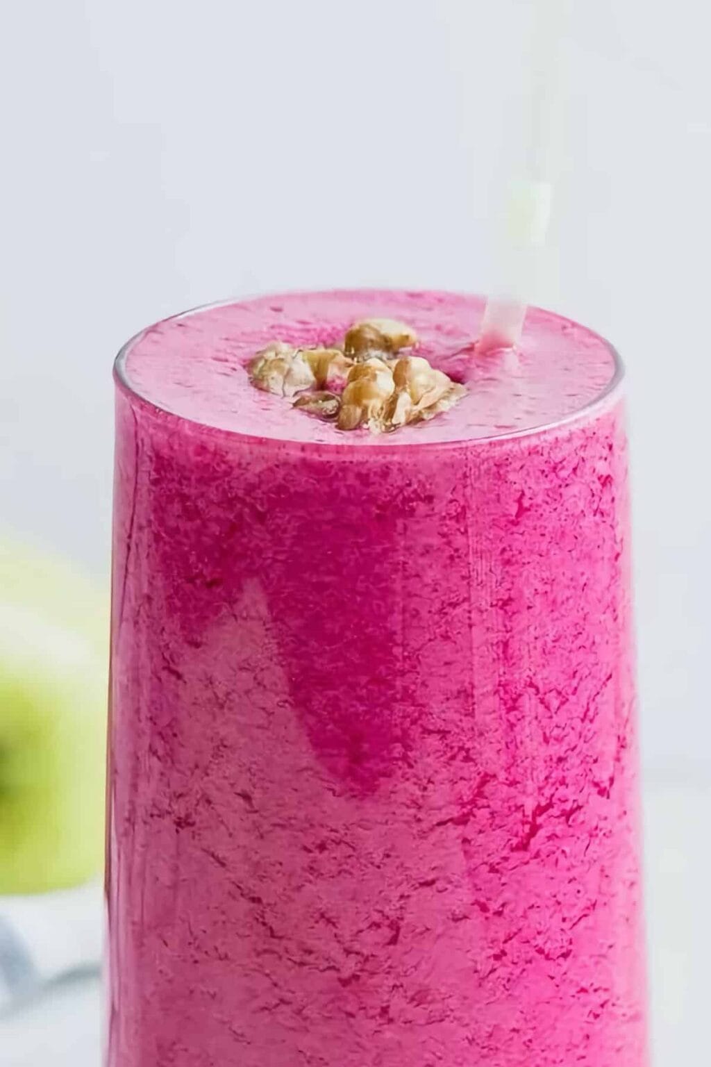 Simply Great Detox smoothie in a glass, on my kitchen counter, surrounded by fresh fruit and vegetables.