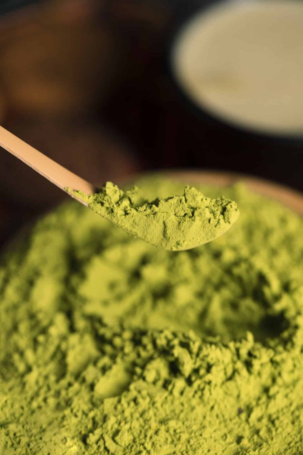 Matcha green tea powder on a bamboo spoon.