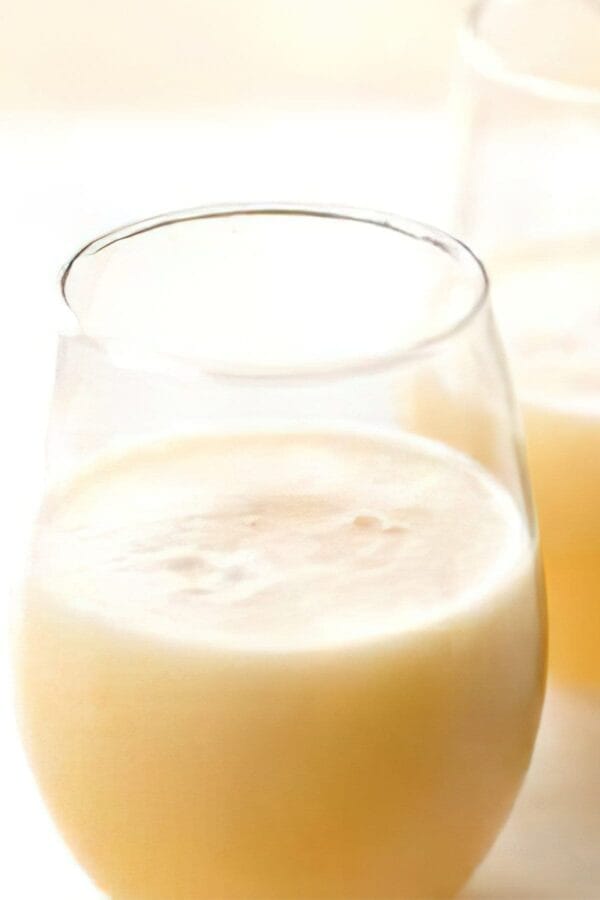 Ninja Blender Cool Ginger Pear smoothie in a glass, on my kitchen counter, surrounded by fresh fruit.