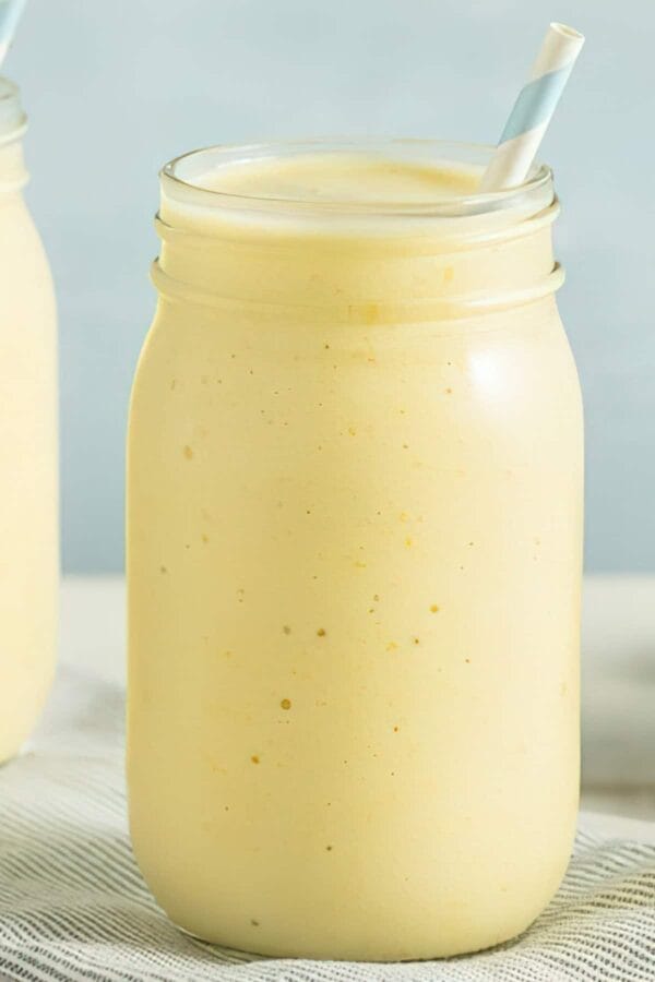 Ninja Blender Creamy Banana Orange Protein smoothie in a glass, on my kitchen counter.