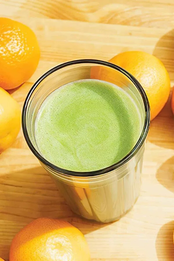 Ninja Blender Tangerine Protein Machine smoothie in a glass, on my kitchen counter, surrounded by fresh fruit.