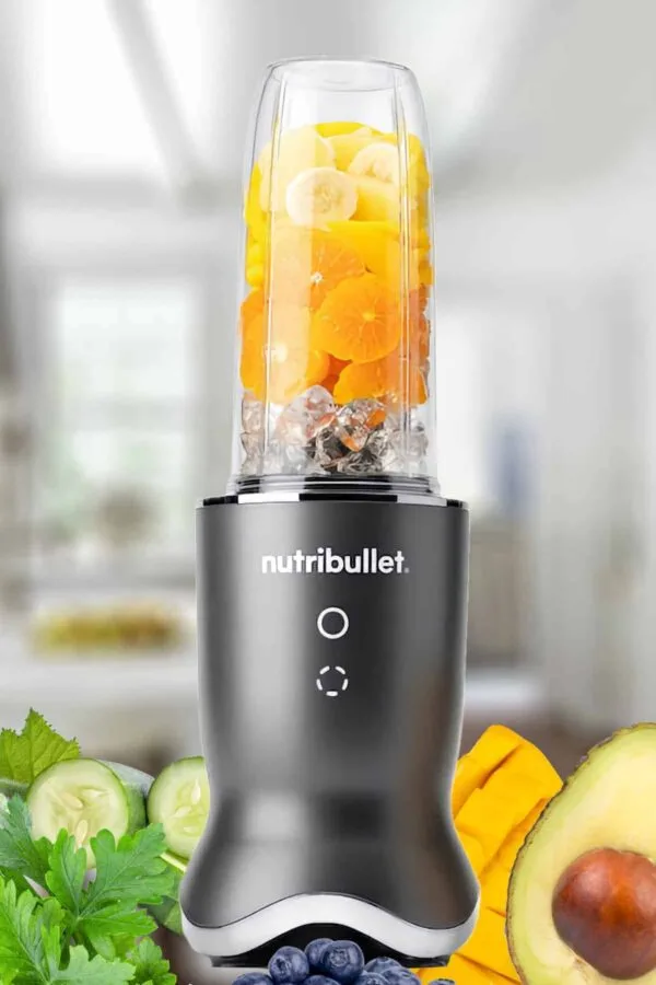 NutriBullet blender blending a NutriBullet smoothie, on my kitchen counter, surrounded by fresh fruit and vegetables.