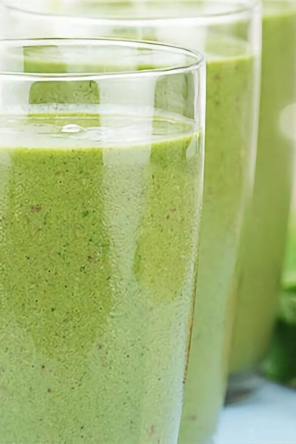 Green Tea Weight Loss smoothie in a glass, on my kitchen counter, surrounded by loose tea.
