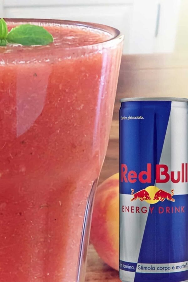 Red Bull Energy smoothie in a glass, on my kitchen counter, next to a can of Red Bull Energy Drink.