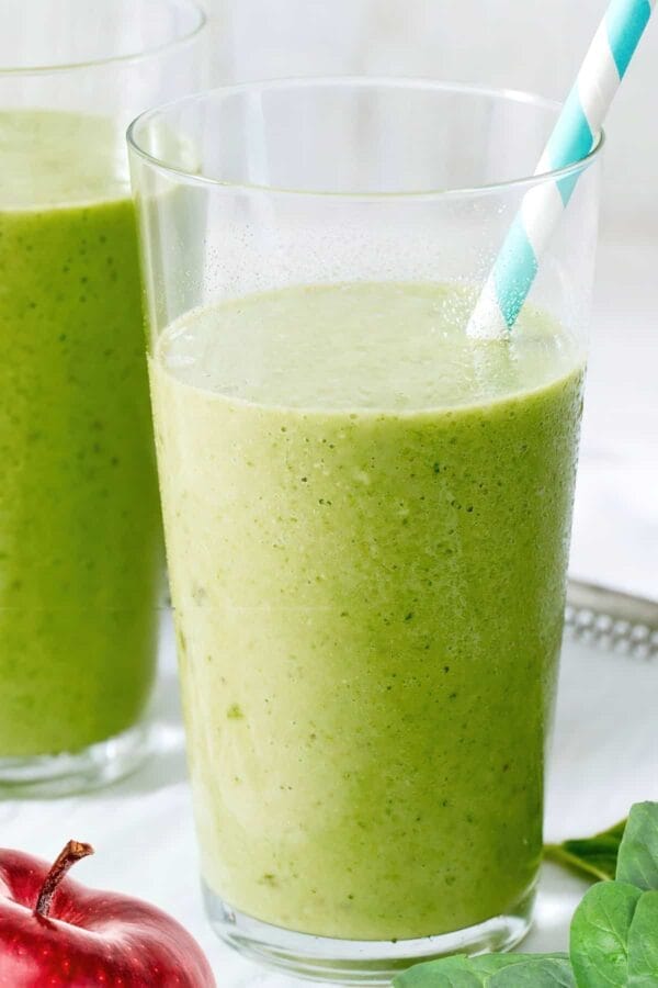 NutriBullet Fiberlicious smoothie in a glass, on my kitchen counter, surrounded by fresh fruit and vegetables.