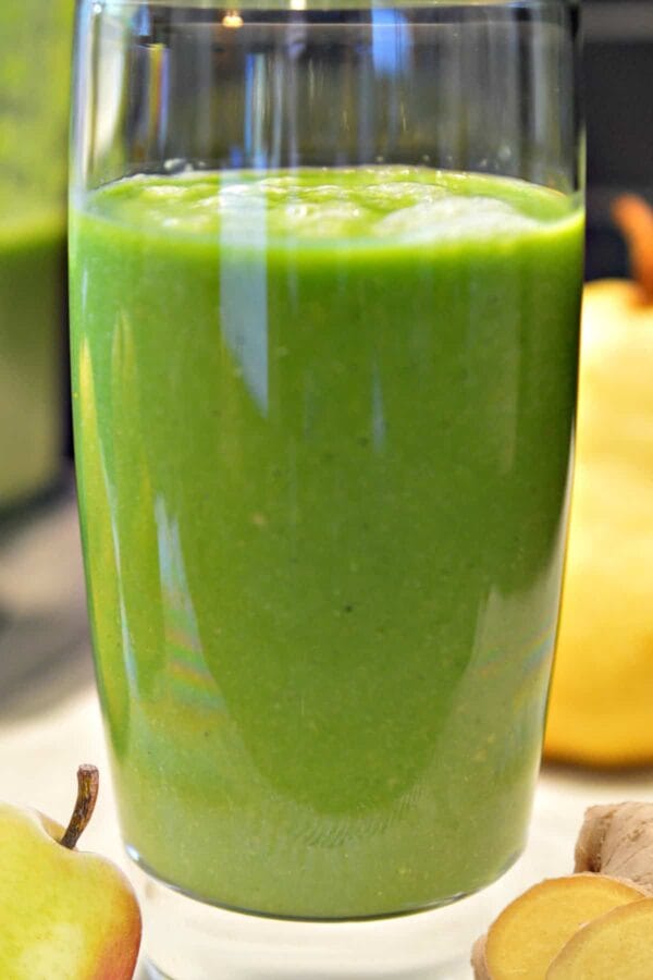 NutriBullet Pear Spiced smoothie in a glass, on my kitchen counter, surrounded by fresh fruit.