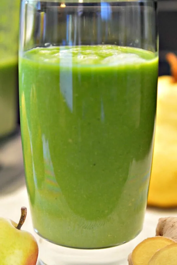 NutriBullet Pear Spiced smoothie in a glass, on my kitchen counter, surrounded by fresh fruit.