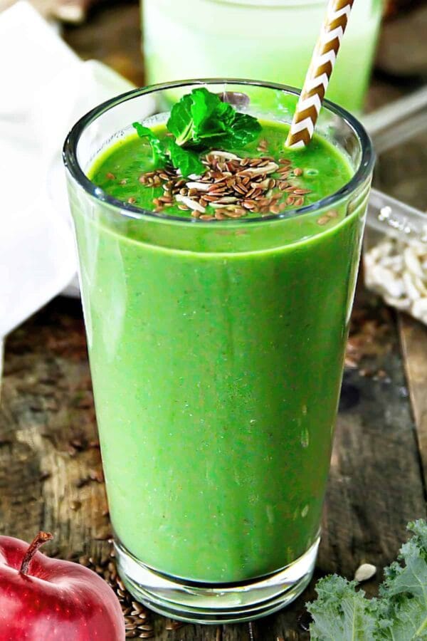 NutriBullet Runner's Favorite smoothie in a glass, on my kitchen counter, surrounded by fresh fruit and vegetables.