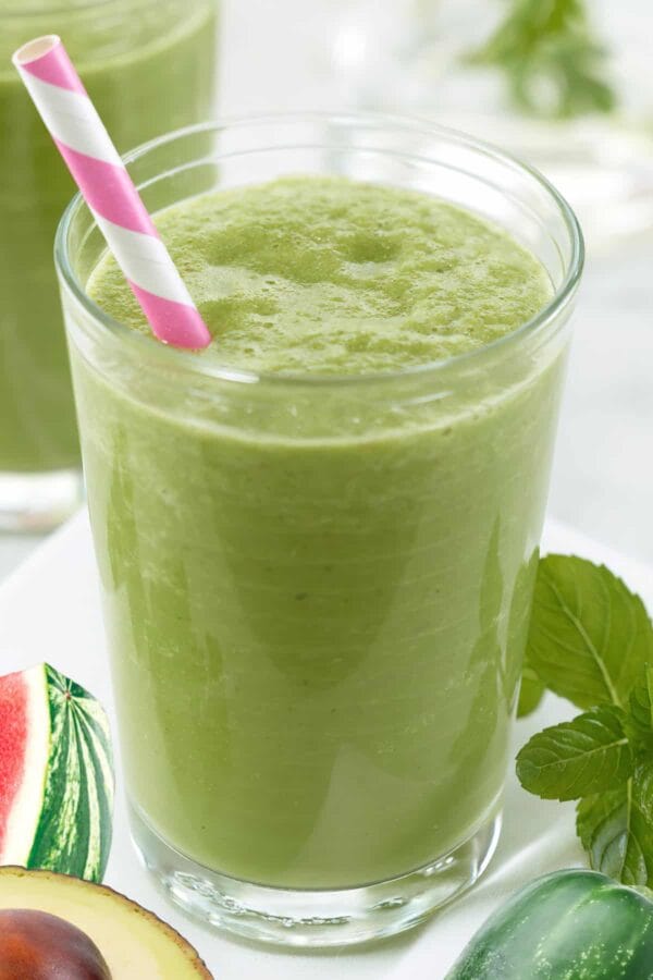 NutriBullet Spa Spot smoothie in a glass, on my kitchen counter, surrounded by fresh fruit.