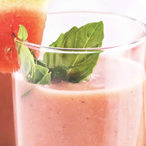 NutriBullet Watermelon Kiwi Nectar smoothie in a glass, on my kitchen counter, surrounded by fresh fruit.