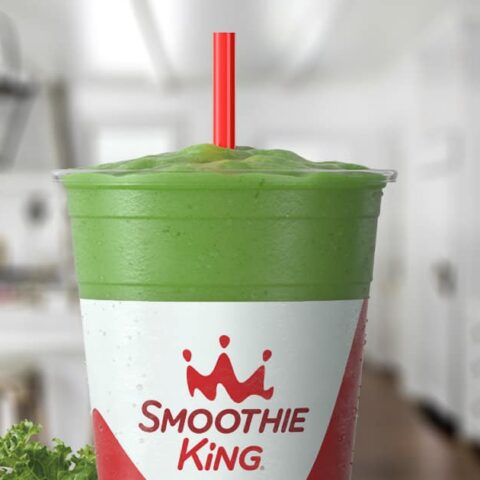Smoothie King Slim-N-Trim Veggie smoothie in a glass, on my kitchen counter, surrounded by fresh vegetables.