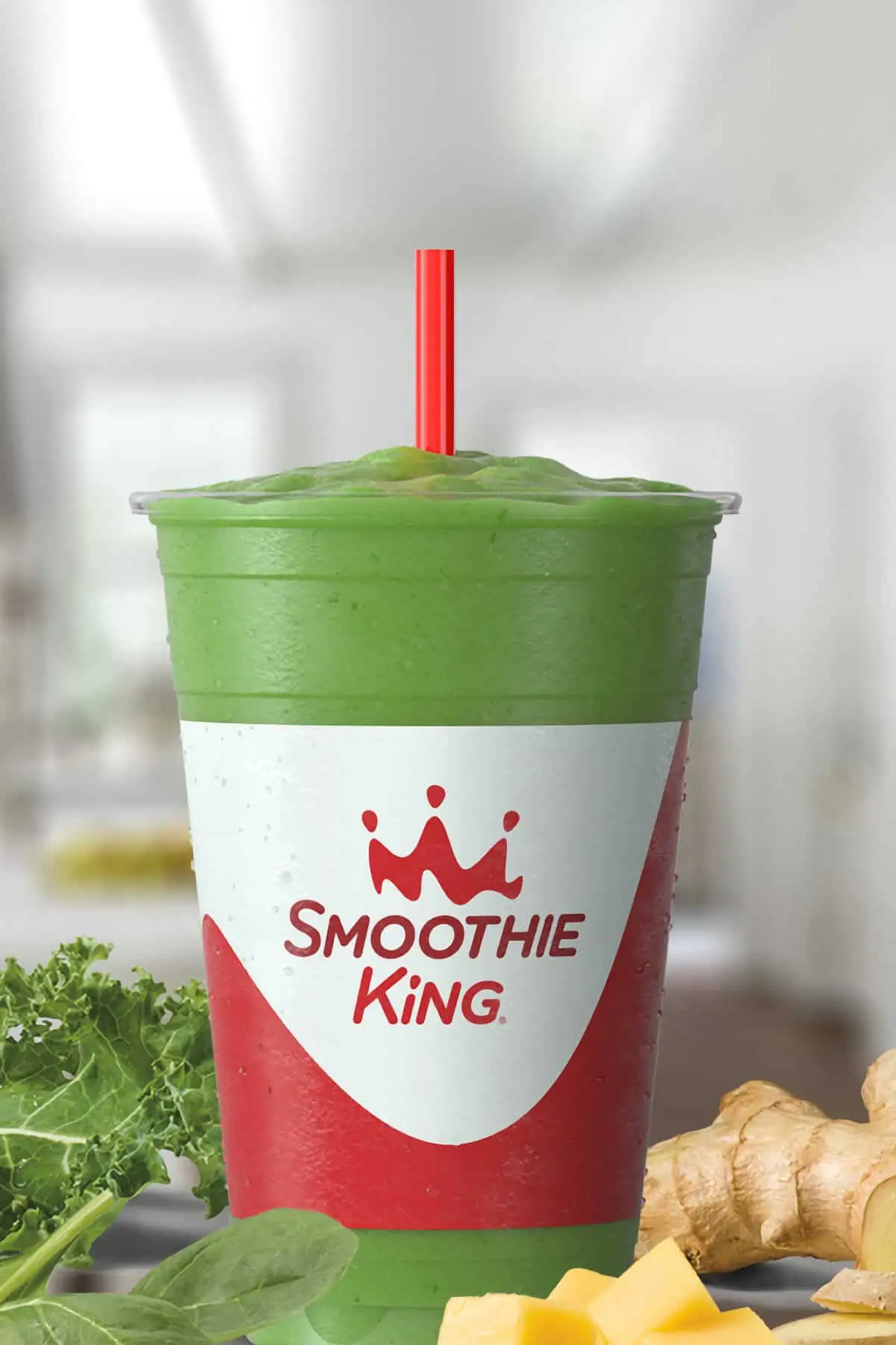 Smoothie King Slim-N-Trim Veggie smoothie in a glass, on my kitchen counter, surrounded by fresh vegetables.