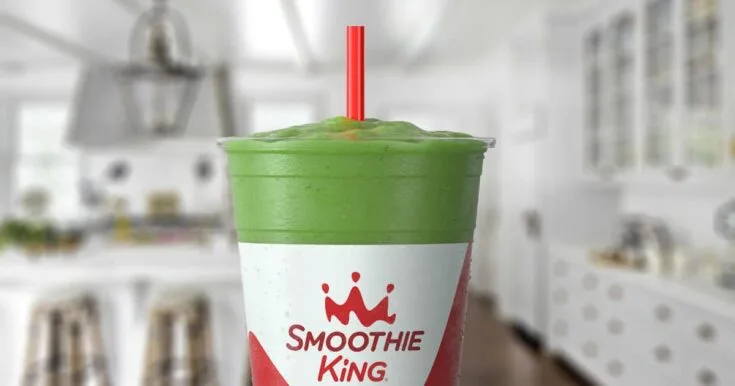 Smoothie King Veggie Lemon Ginger Spinach 12 Smoothie King Veggie Lemon Ginger Spinach smoothie in a glass, on my kitchen counter, surrounded by fresh spinach and ginger.