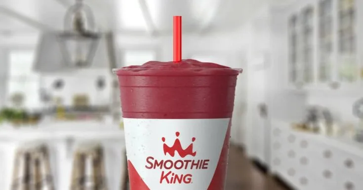 Smoothie King Blueberry Lemonade 9 Smoothie King Berry Lemonade smoothie in a glass, on my kitchen counter, surrounded by fresh strawberries and blueberries.