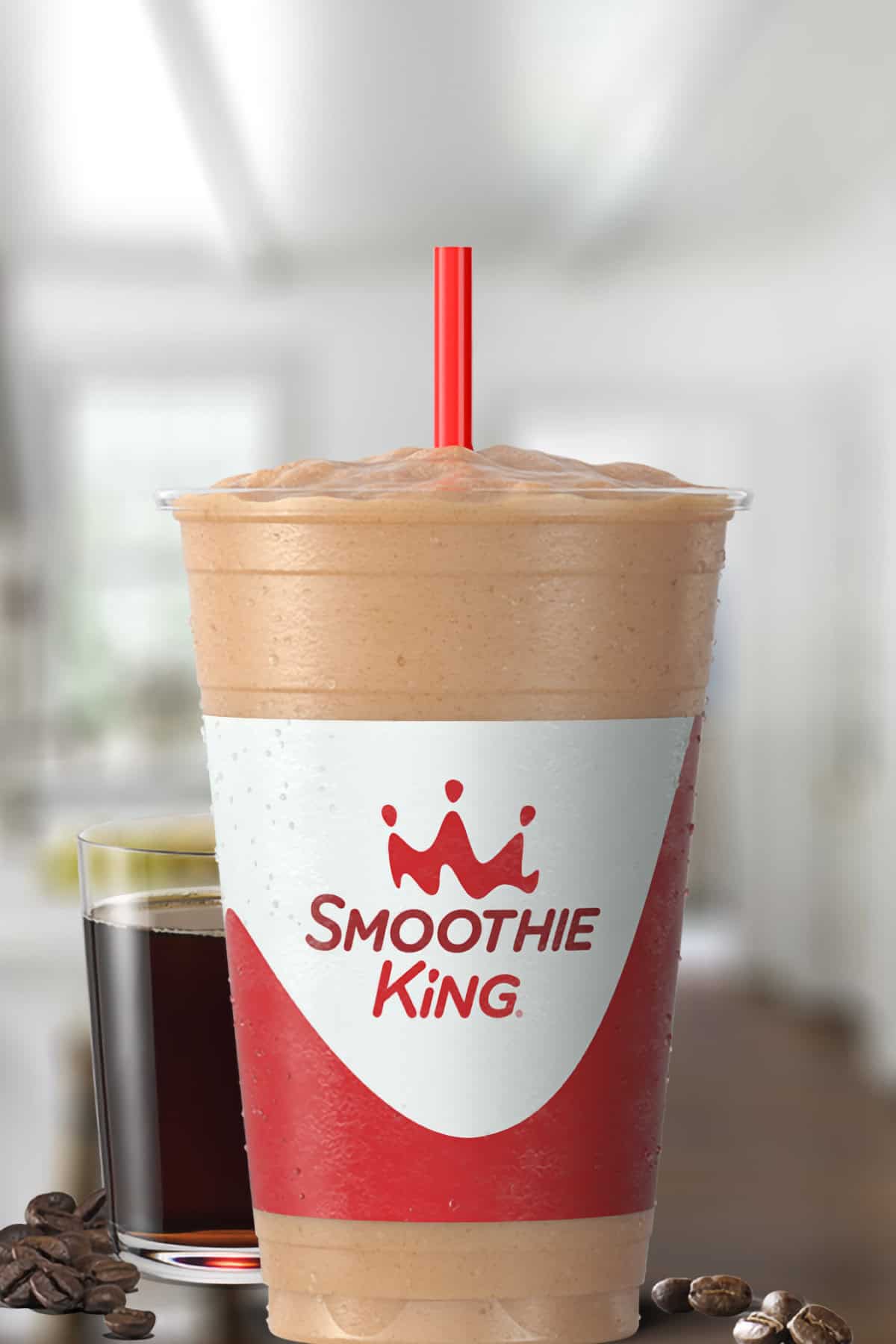 Smoothie King Coffee D-Lite Mocha smoothie in a glass, on my kitchen counter, surrounded by coffee beans.