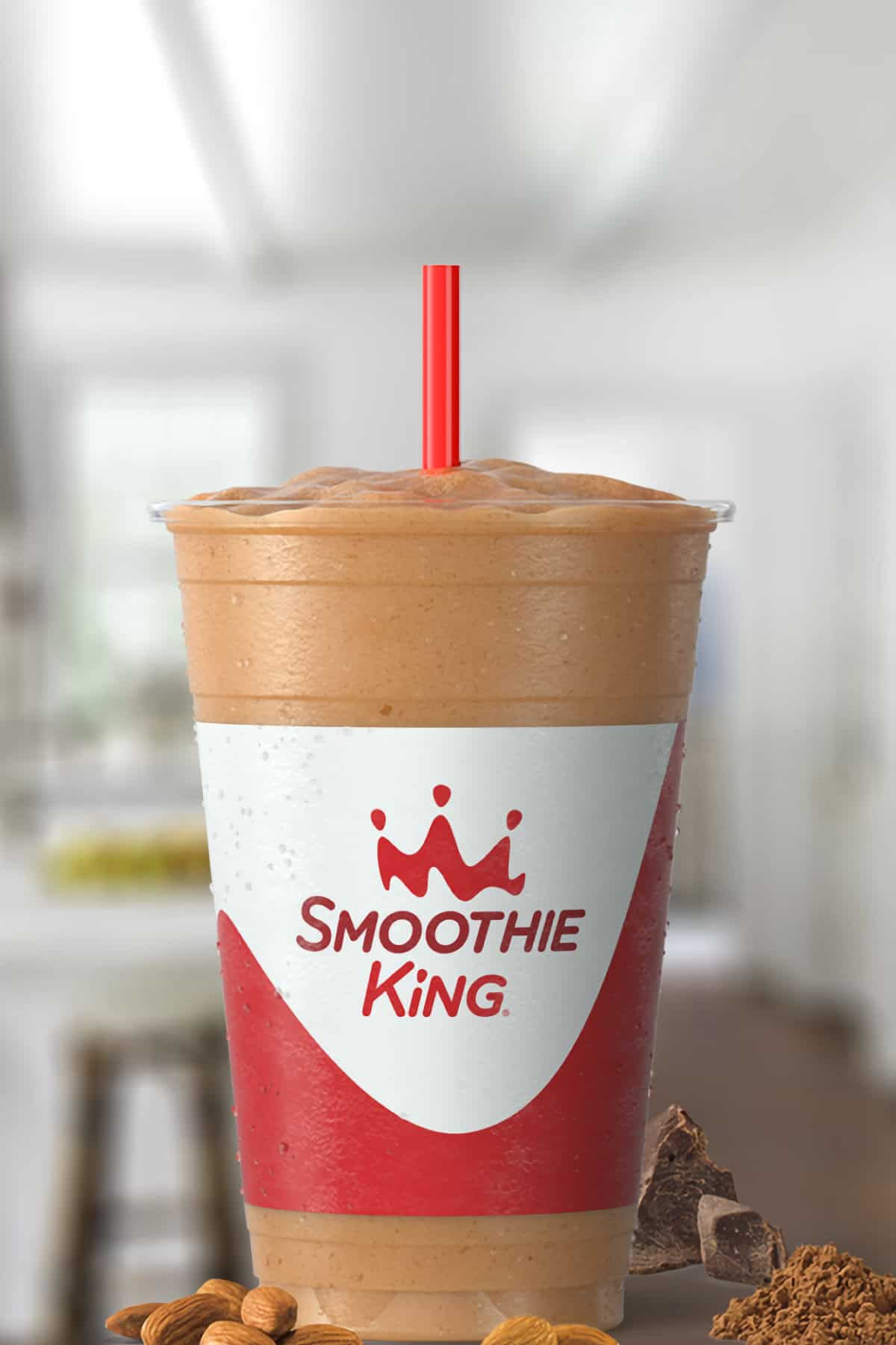 Smoothie King Espresso High Protein Vanilla smoothie in a glass, on my kitchen counter, surrounded by almonds and chocolate.