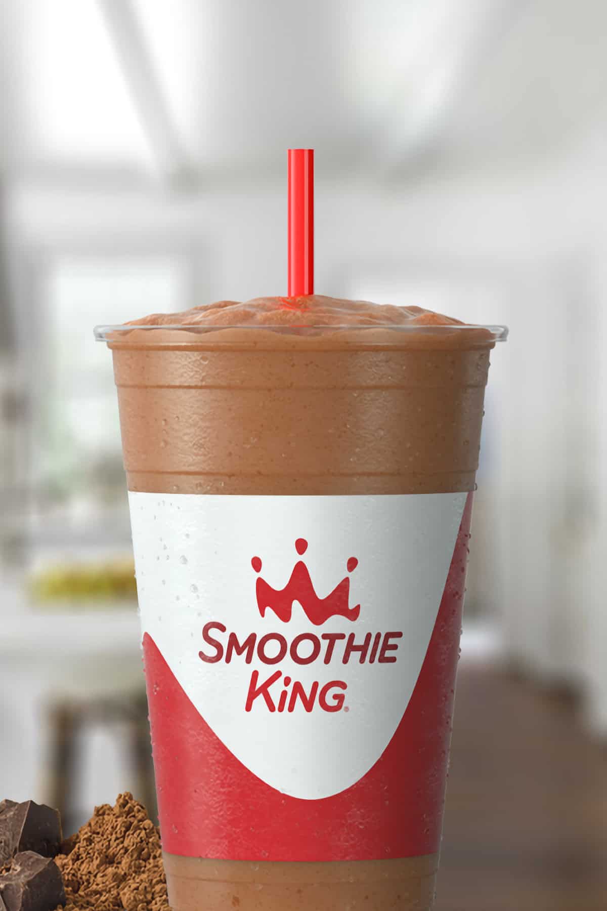 Smoothie King Original High Protein Chocolate smoothie in a glass, on my kitchen counter, surrounded by cacao.