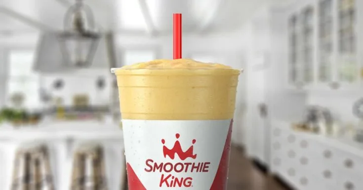 Smoothie King The Activator Recovery Pineapple 8 Smoothie King The Activator Recovery Pineapple smoothie in a glass, on my kitchen counter, surrounded by pineapples and sliced bananas.