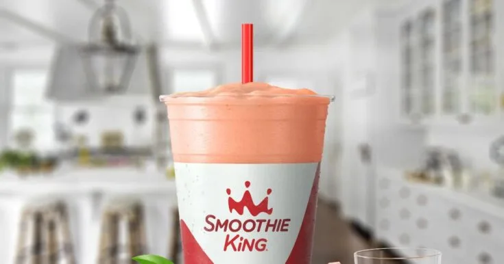 Smoothie King Watermelon Lemonade 8 Smoothie King Watermelon Lemonade smoothie in a glass, on my kitchen counter, surrounded by fresh lemons and watermelon slices.