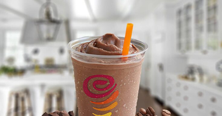 Jamba Juice Buzzin' Mocha Moo'd smoothie in a glass, on my kitchen counter, surrounded by chocolate chunks and roasted coffee beans.