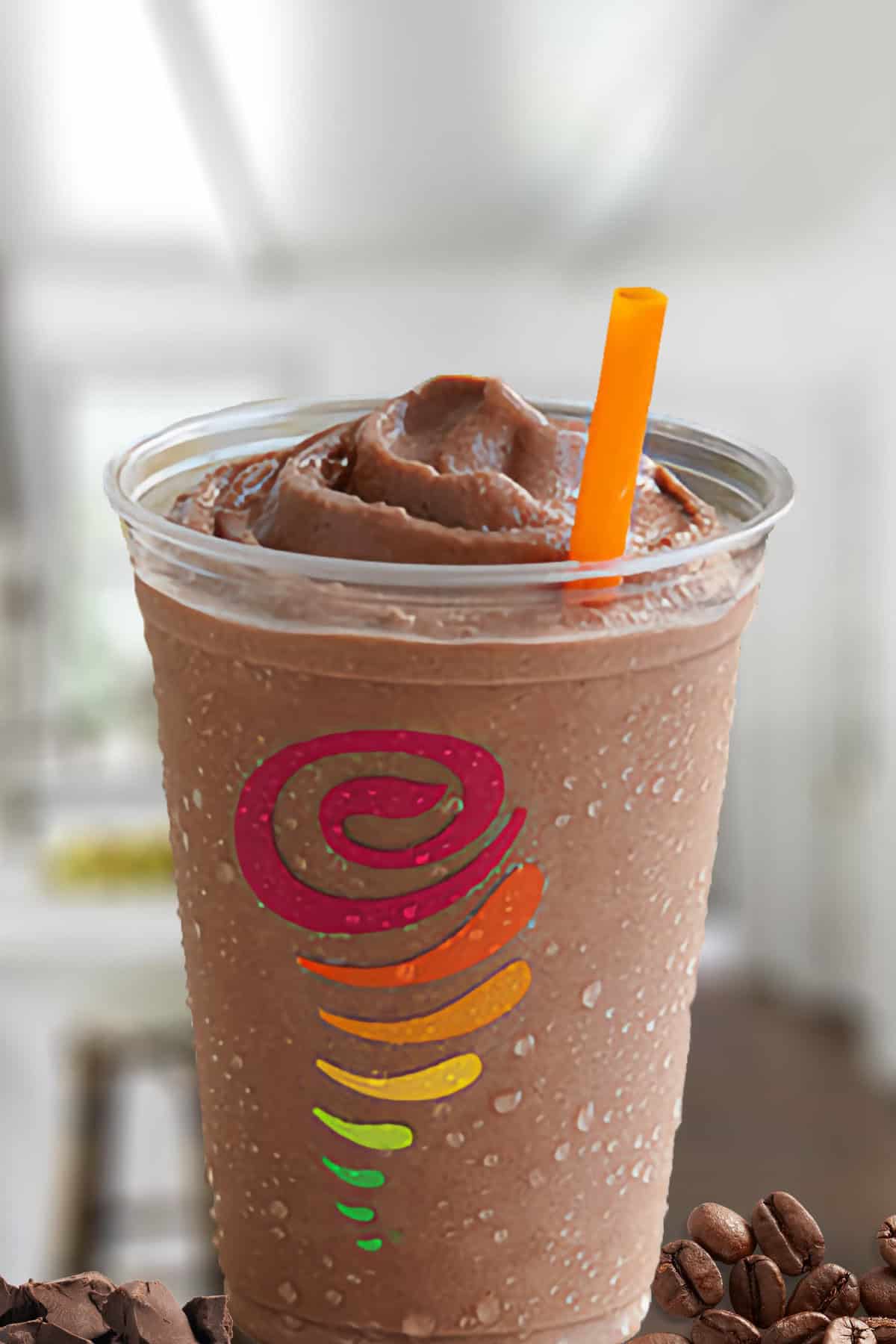 Jamba Juice Buzzin' Mocha Moo'd smoothie in a glass, on my kitchen counter, surrounded by chocolate chunks and roasted coffee beans.