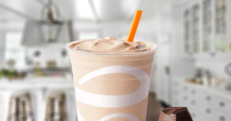 Jamba Juice PB Chocolate Love smoothie in a glass, on my kitchen counter, surrounded by chocolate chunks.