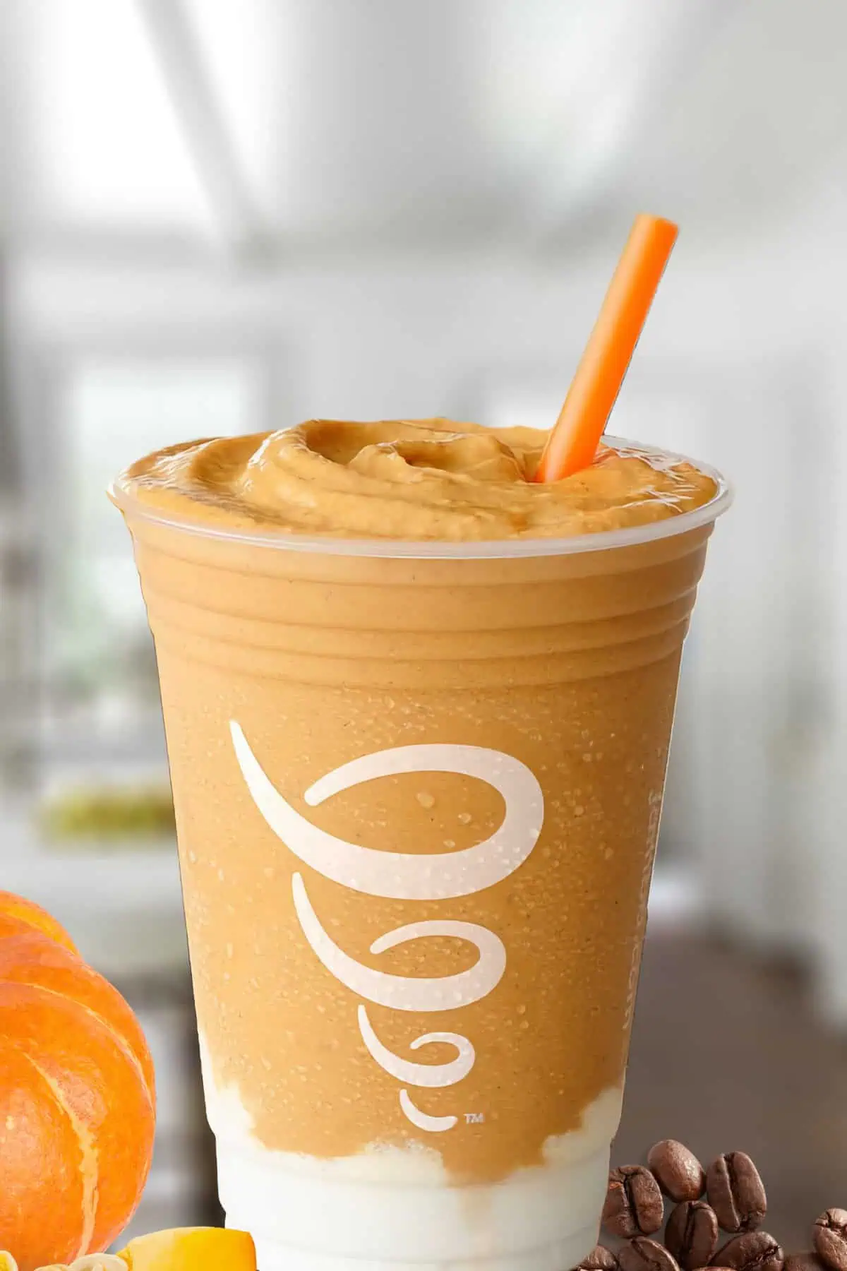 Jamba Juice Pumpkin Coffee smoothie in a glass, on my kitchen counter, surrounded by pumpkins and freshly roasted coffee beans.