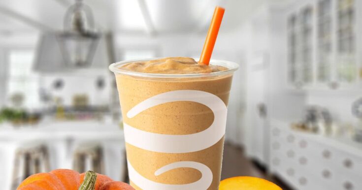 Jamba Juice Pumpkin Smash smoothie in a glass, on my kitchen counter, surrounded by pumpkins.