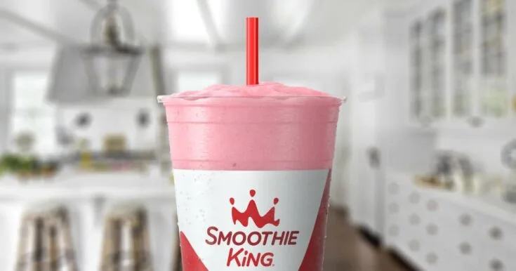 Smoothie King Power Slim Strawberry 6 Smoothie King Power Slim Strawberry smoothie in a glass, on my kitchen counter, surrounded by fresh strawberries.