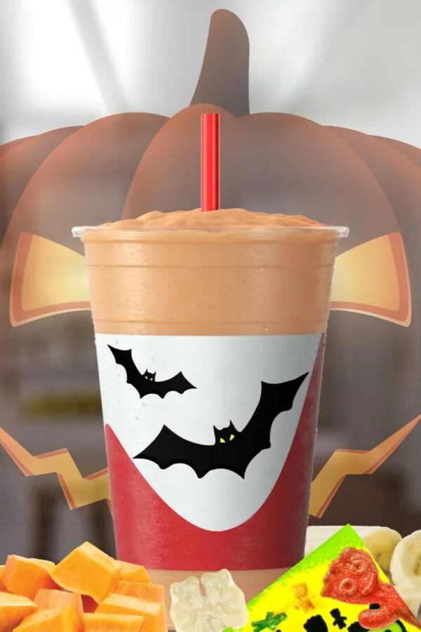 Spooky Halloween smoothie on my kitchen counter surrounded by fresh fruit and candy.