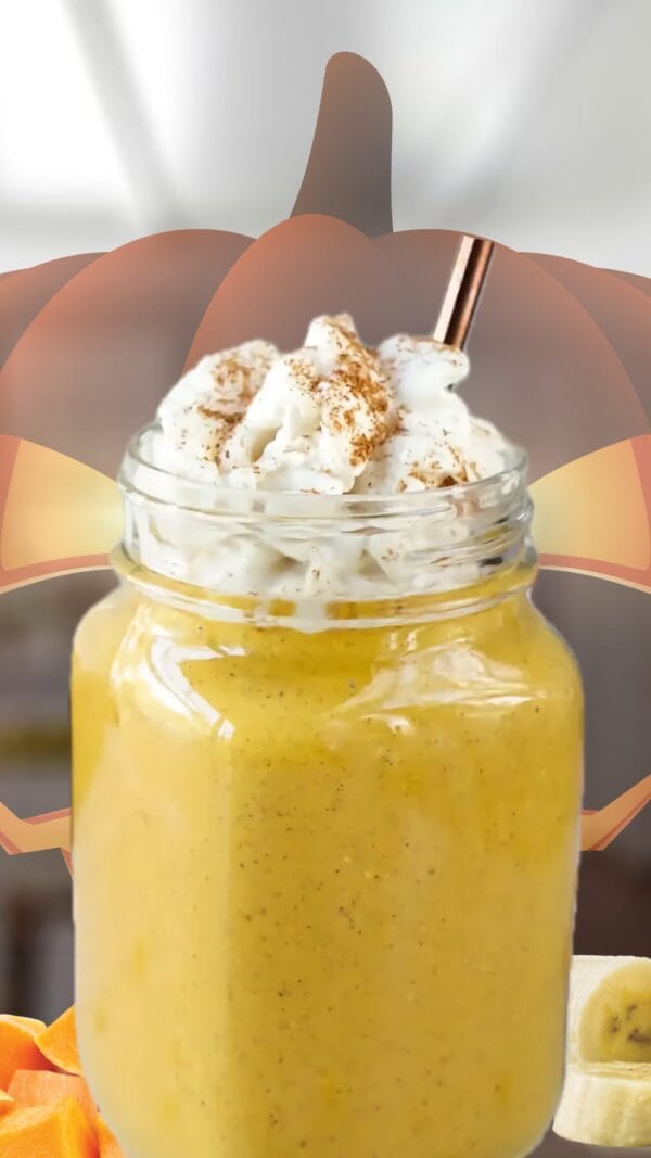 Pumpkin Banana Halloween smoothie in a glass, on my kitchen counter, surrounded by fresh pumpkin and bananas.