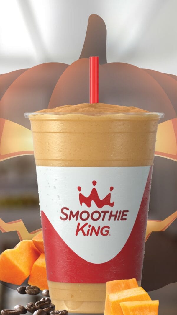 Pumpkin Coffee High-Protein Halloween smoothie in a glass, on my kitchen counter, surrounded by pumpkins and coffee beans.