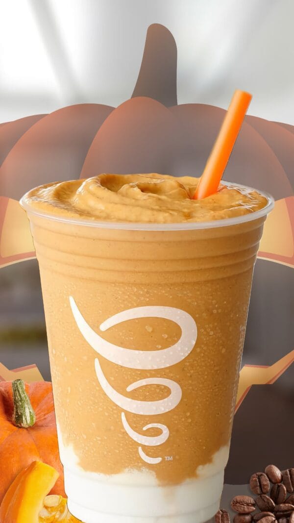 Pumpkin Coffee Halloween smoothie in a glass, on my kitchen counter, surrounded by fresh pumpkins and coffee beans.