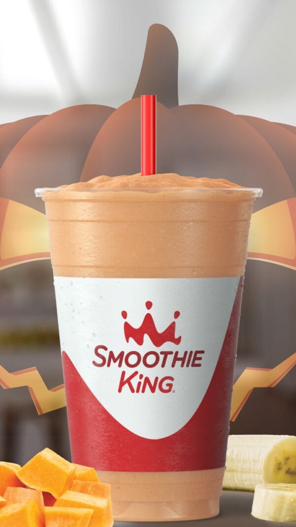 Pumpkin Slim-N-Trim Halloween smoothie in a glass, on my kitchen counter, surrounded by pumpkins and bananas.