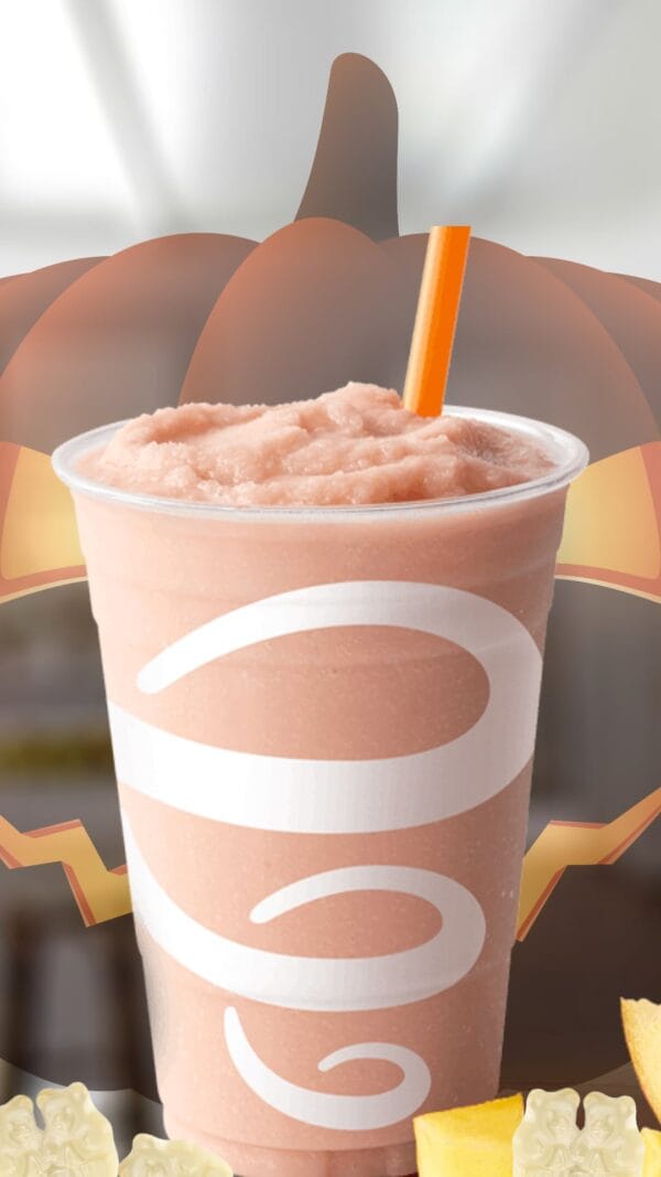 White Gummi Bear Halloween smoothie in a glass, on my kitchen counter, surrounded by Albanese Gummi Bears.